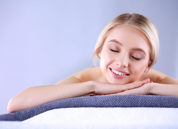 Young woman lying on a massage tablerelaxing with eyes closed