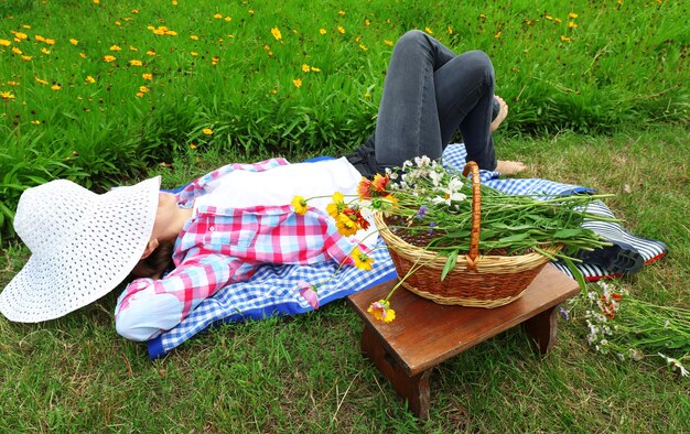 屋外の牧草地に横たわる若い女性