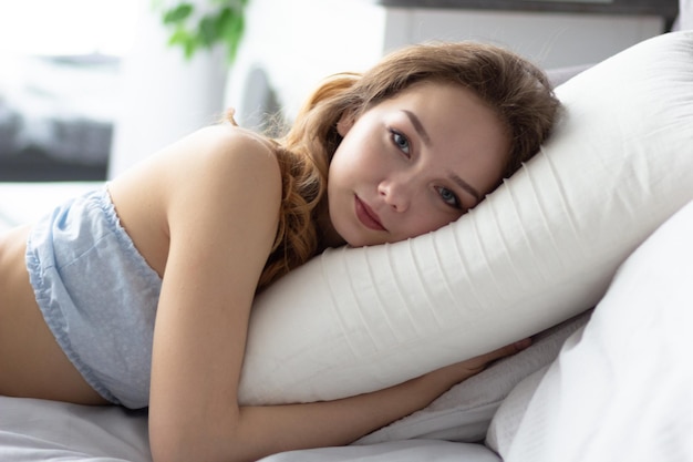 Young woman lying on pillow in the bedroom