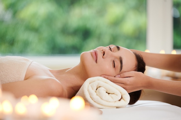 Young woman lying and relaxing during spa massage