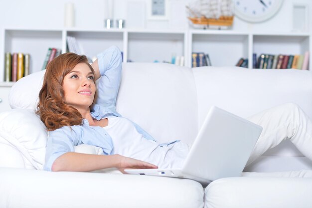 Young woman lying with laptop