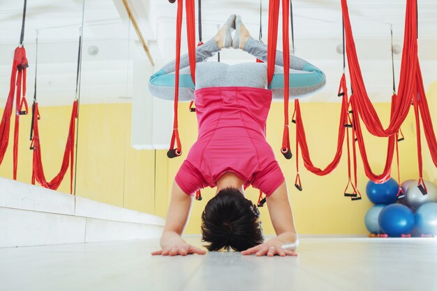 Young woman making antigravity yoga exercises