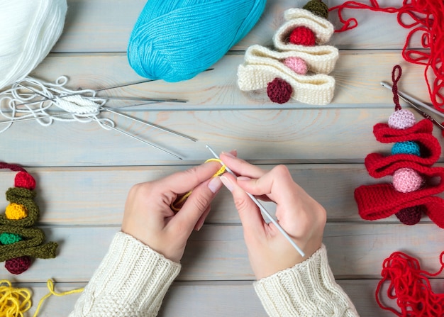 Young woman making Christmas handmade toys on wooden table