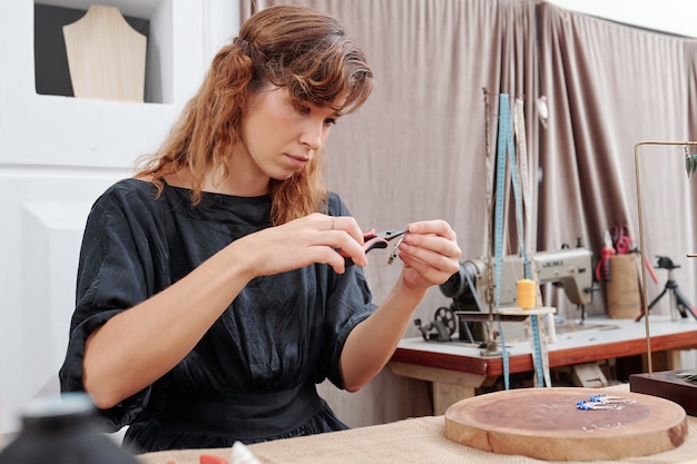 Young woman making earrings