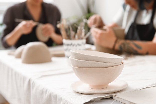 Young woman making earthen pot in pottery workshop