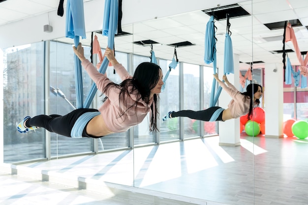 写真 空中ヨガの練習をする若い女性