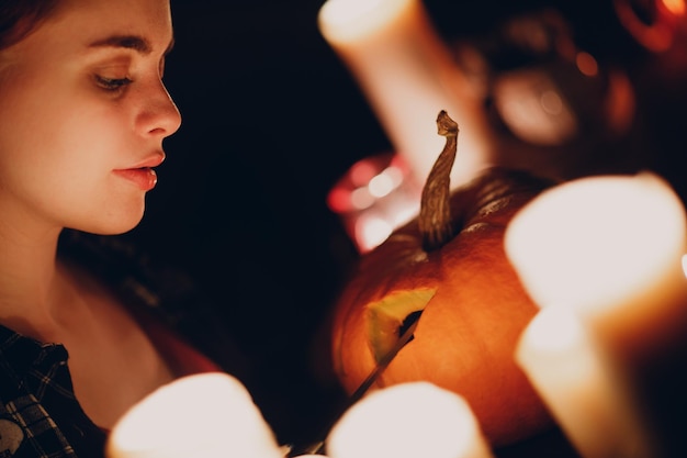 Giovane donna che fa la zucca di halloween jackolantern mani femminili che tagliano le zucche con il coltello