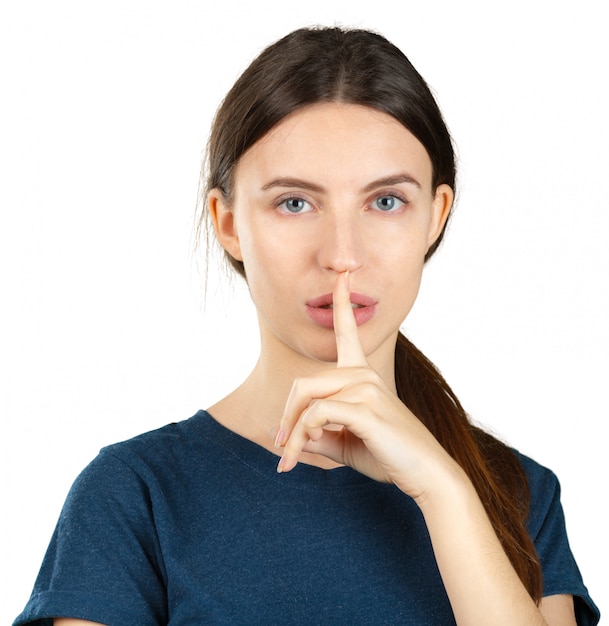 Young woman making silence gesture