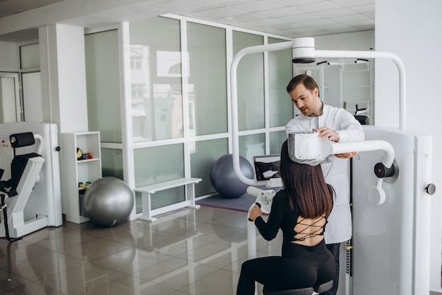 Photo young woman making spine examination in diagnostics machine with physiotherapist