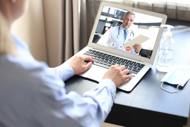 Young woman making video call with her doctor during self isolation and quarantine