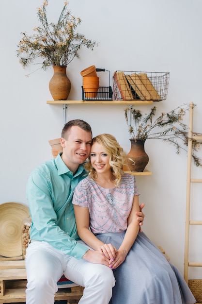 Young woman and man are sitting and holds hands in the interior of an eco clay pot. DIY interior concept