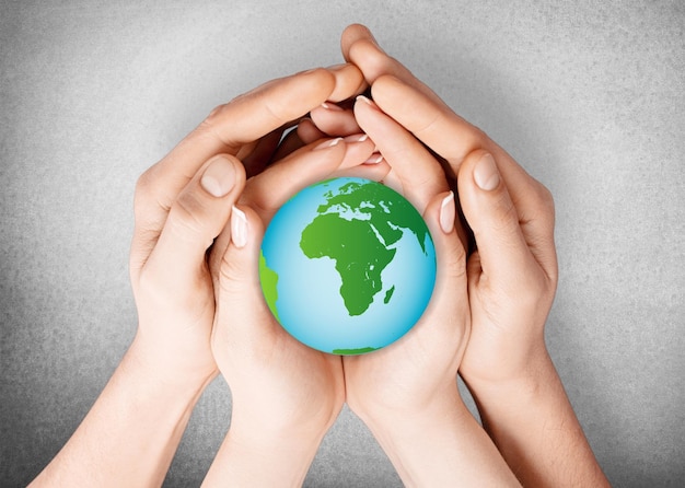 Young woman and man holding green globe in hands