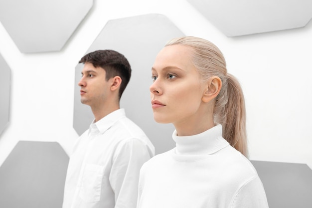 Young woman and man standing with the back to wall