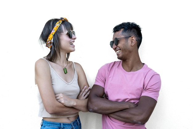 Young woman and man with sunglasses looking each other and
laughing portrait of generation z people having fun