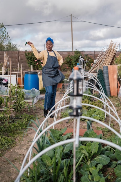 가족을 위해 작은 채소 정원을 관리하는 젊은 여성 개념 농업