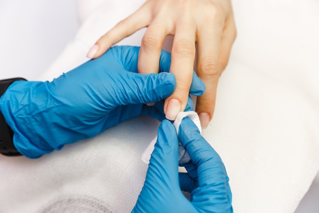 Young woman on manicure treatment in beauty salon. Manicure, beauty procedures and personal care