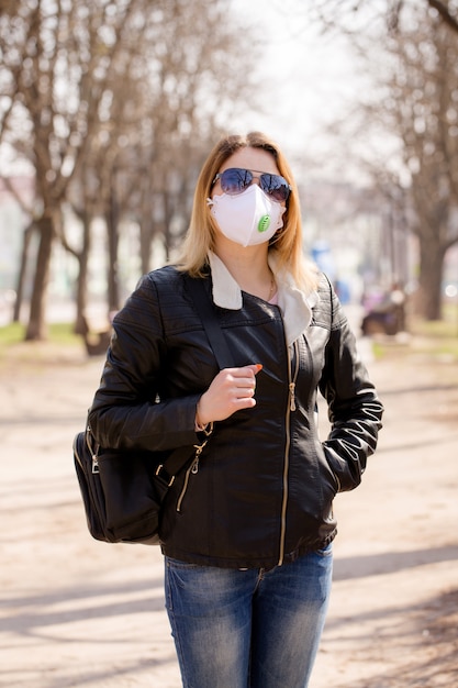 Young woman in a mask is walking