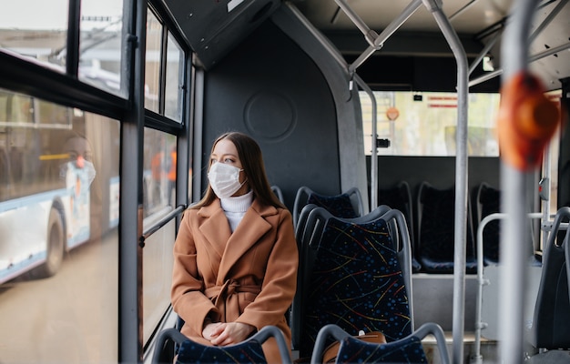 Young woman in a mask uses public transport