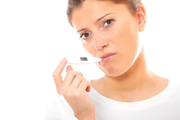 young woman measuring temperature over white background