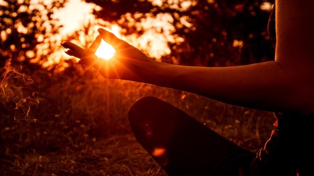 Foto una giovane donna medita e si rilassa al tramonto o all'alba