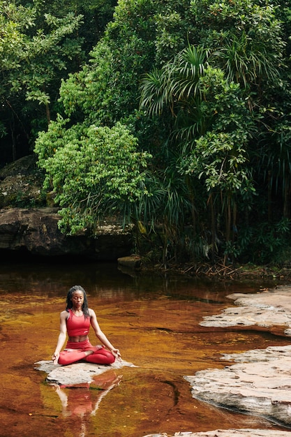 Young woman meditating in forest