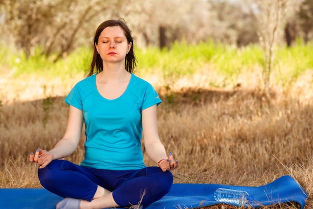 Young woman meditating in the forest