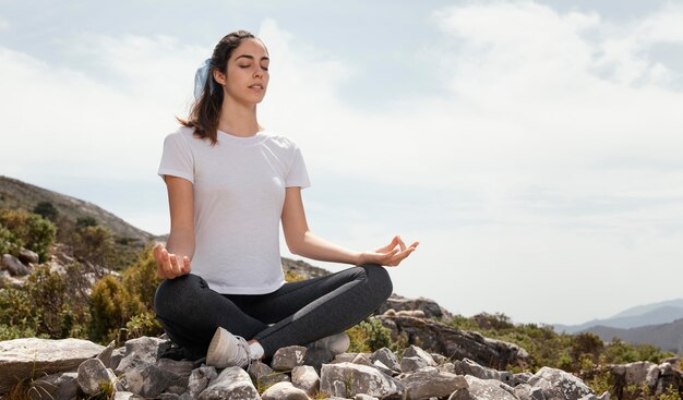 Giovane donna meditando all'aperto