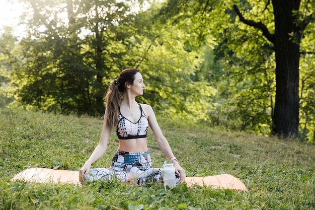 Photo young woman meditating in the park