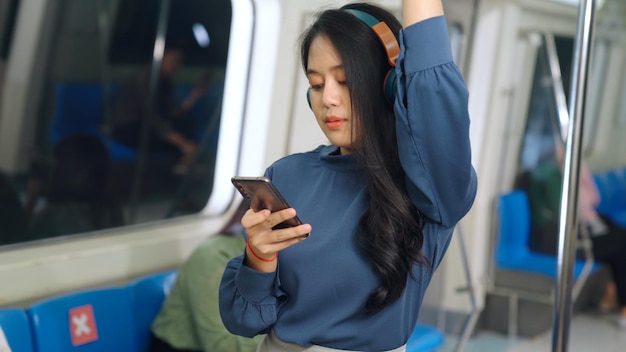 Young woman mobile phone on public train . Urban city lifestyle commuting concept .