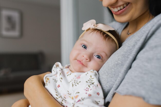 Photo young woman mom with baby girl on hands at home