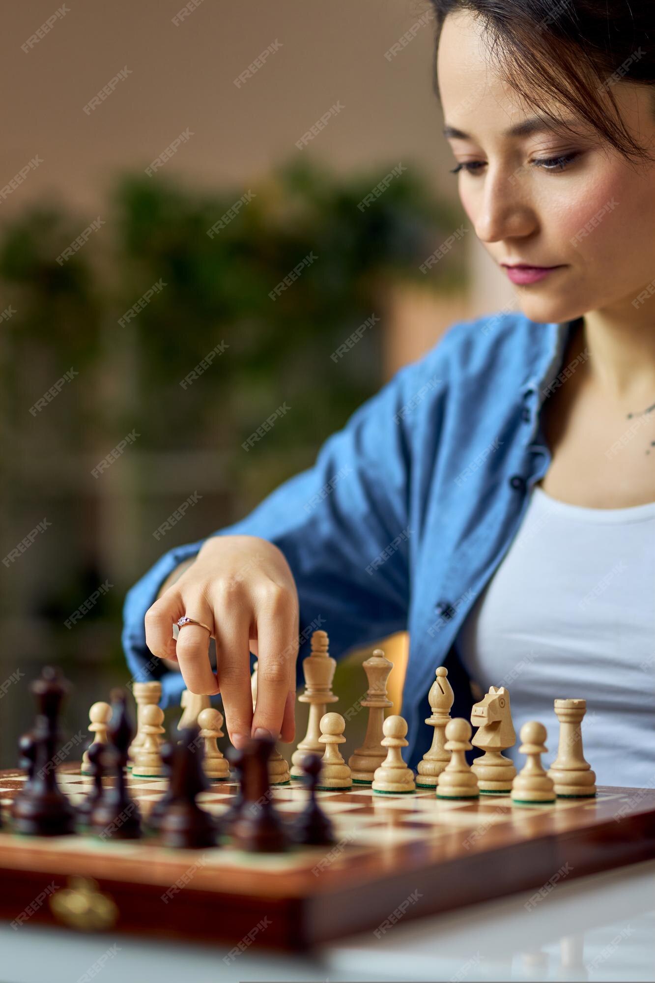 Woman playing chess thinking of next move Stock Photo - Alamy