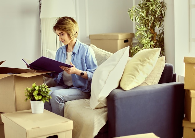 Young woman moving out and packing cardboard box