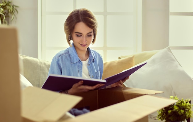 Young woman moving out and packing cardboard box