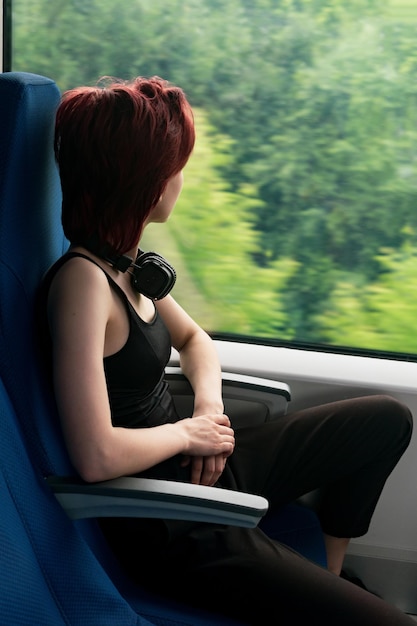 Photo young woman in a moving suburban train looks out the window