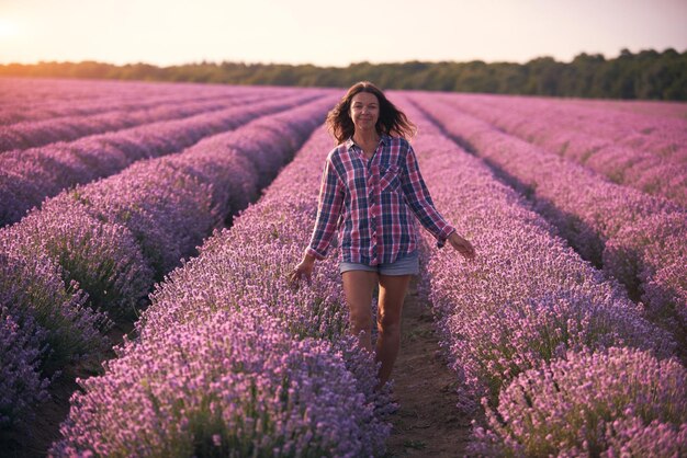 Giovane donna in camicia a quadri multicolore nel bellissimo campo di lavanda