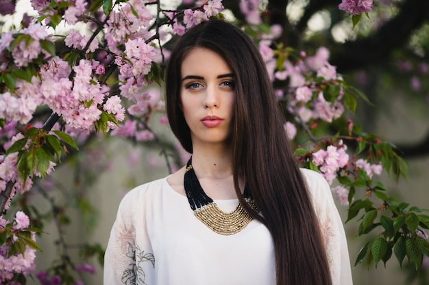 Young woman near blooming tree