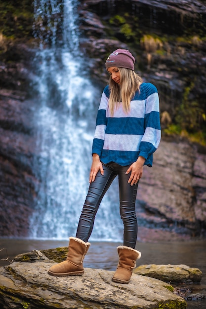 A young woman near a waterfall