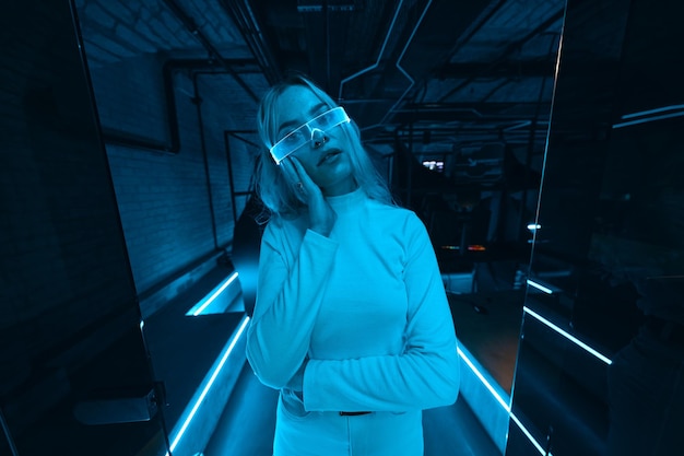 Giovane donna con occhiali al neon stile cyberpunk