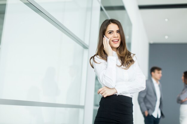 Young woman in office with mobile phone