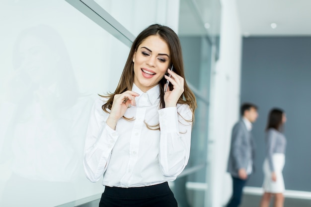 Young woman in office with mobile phone