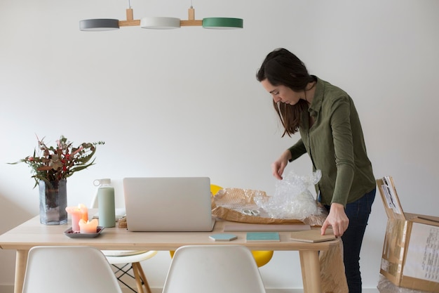 Photo young woman opening a delivery box at home