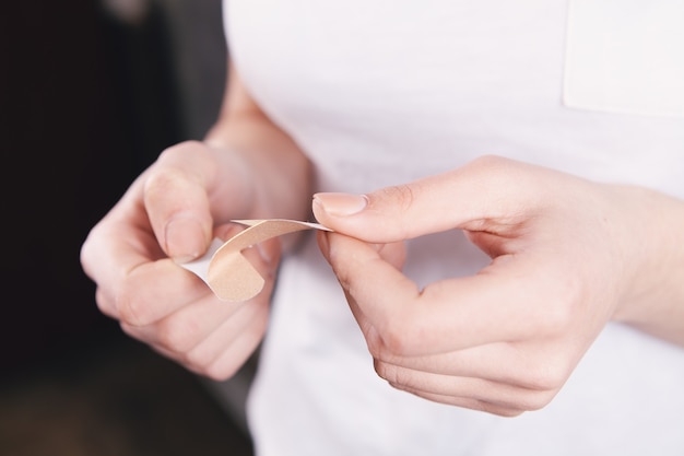 Young woman opens a band-aid