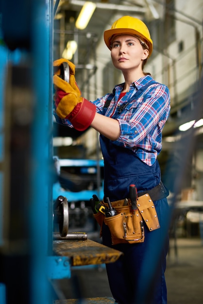 Young Woman Operating Machines in Factory Workshop