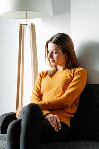 Young woman in an orange jersey waits in a clinic