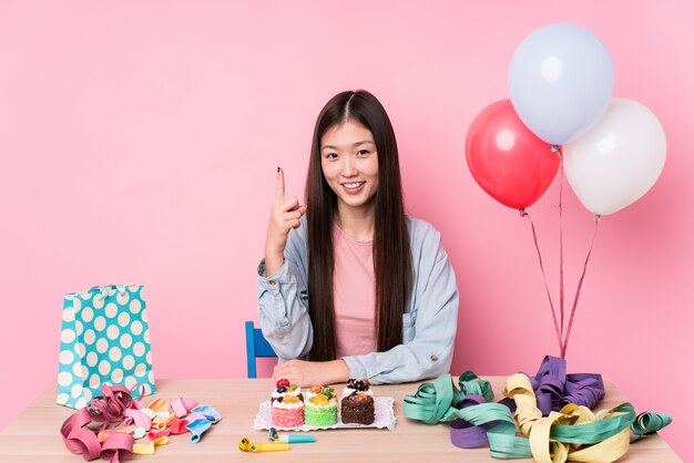 Young woman organizing a birthday isolated showing number one with finger