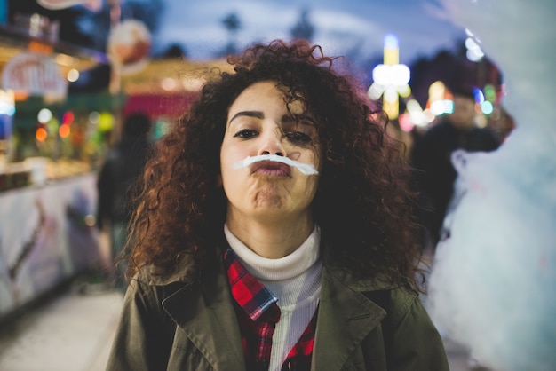 Young woman outdoor playing with cotton candy