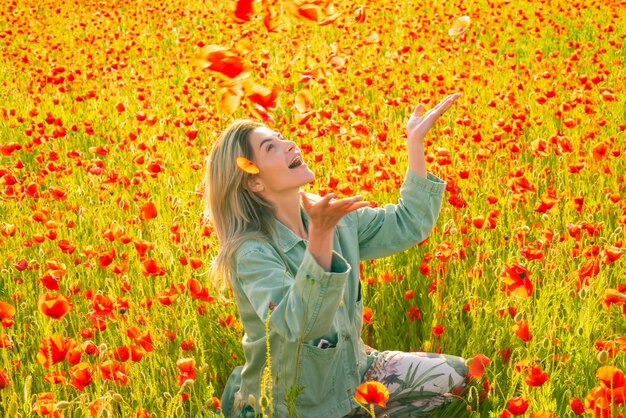 Young woman outdoor in poppy field on poppies background girl in the field of spring blossom floweri