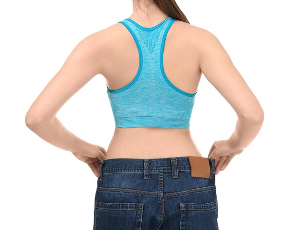 白い背景のオーバーサイズジーンズを着た若い女性 ダイエットコンセプト