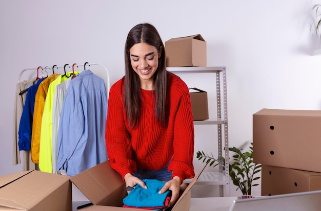 배달을 준비하는 상자에 제품을 포장하는 중소기업의 젊은 여성 소유자 온라인에서 판매하는 제품으로 패키지를 포장하는 여성