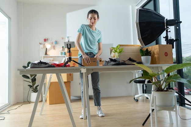 A young woman owner of a small ecommerce business is packing items into the mail box